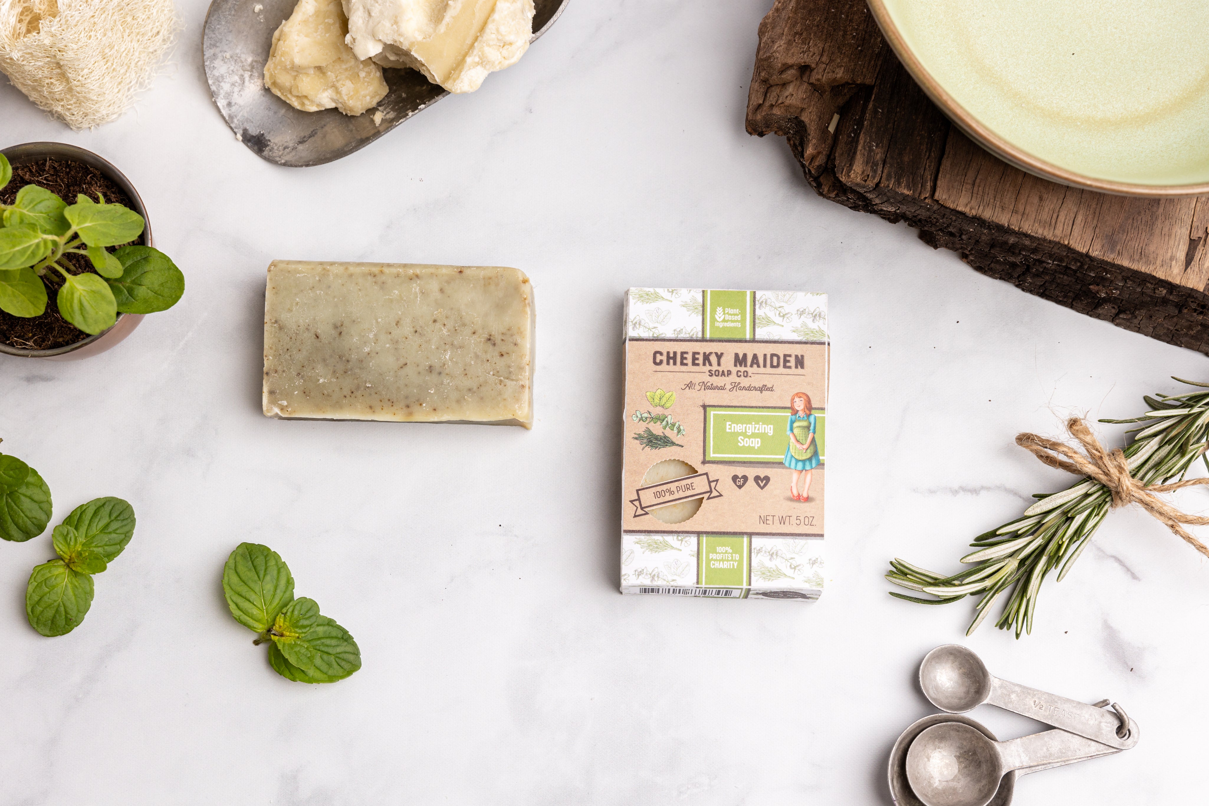 Cheeky Maiden soap packaging with soap bars and herbs on a white surface