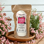 Packaged shower steamers with flowers on a wooden surface