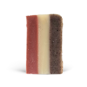 Three-layered soap bar with different textures and colors on a white background