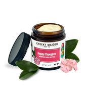 Jar of 'Happy Thoughts' whipped shea butter from Cheeky Maiden Soap Co. with a pink flower and green leaves on a white background.