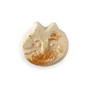 Cat-shaped bath bomb with gold accents on a white background