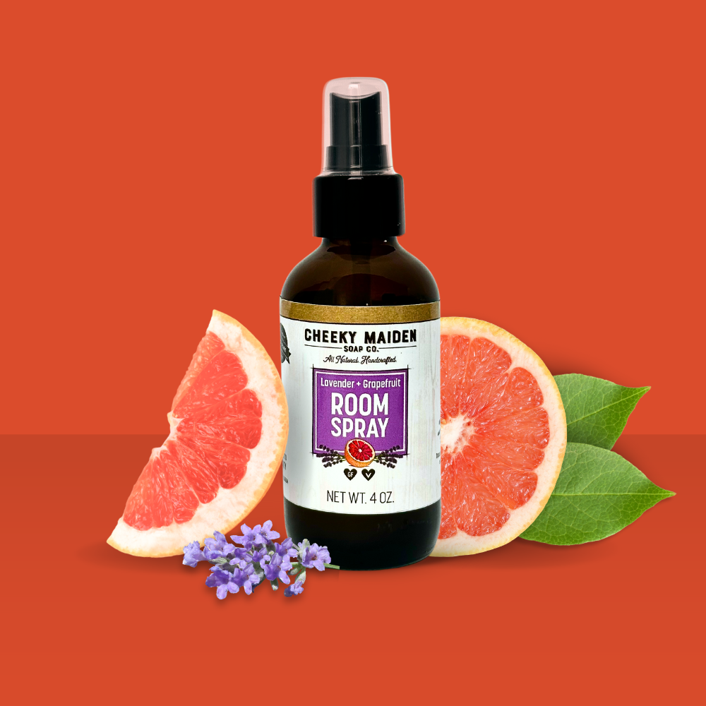 Room spray bottle with grapefruit slices and lavender flowers on an orange background