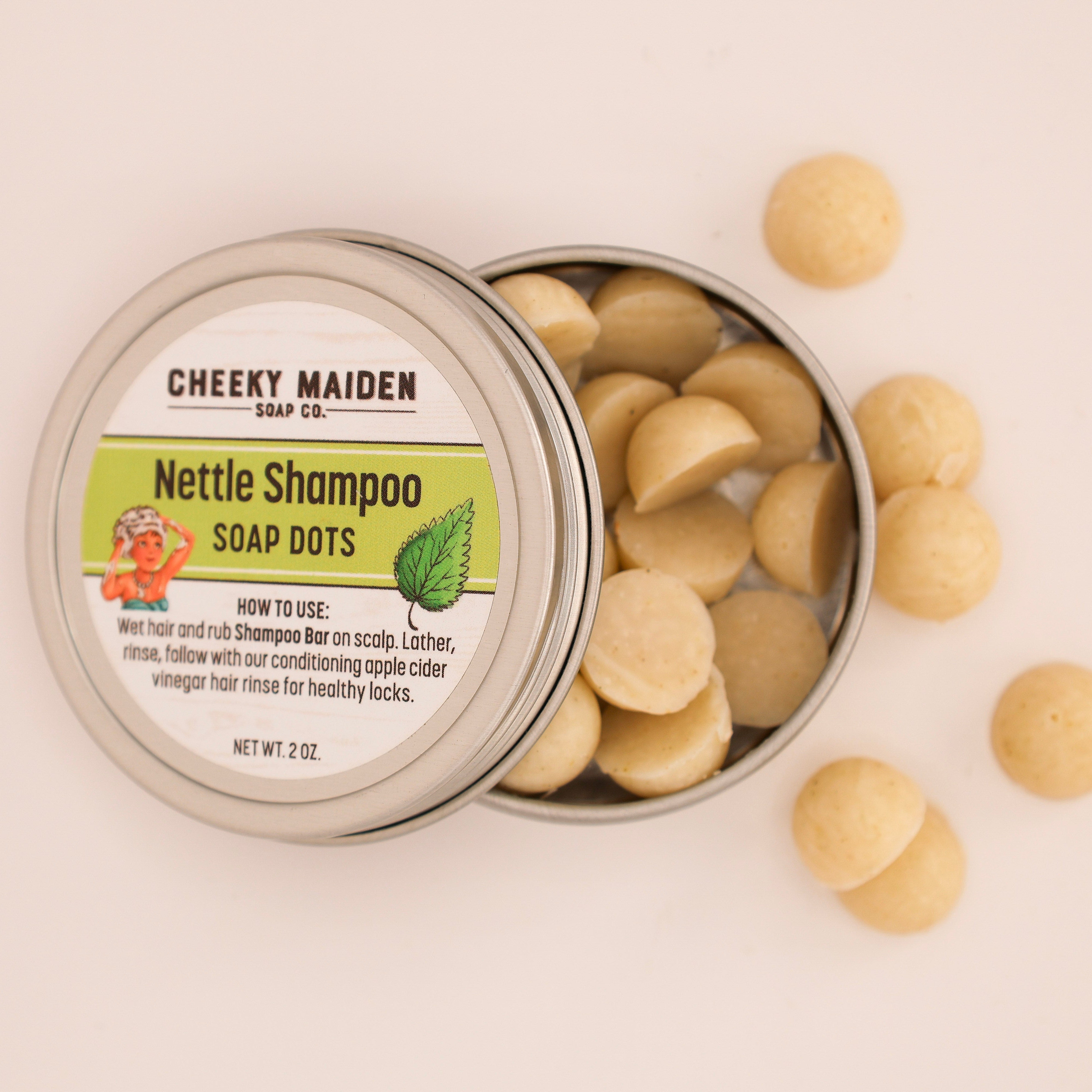 Tin of Nettle Shampoo Soap Dots with packaging labeled 'Cheeky Maiden Soap Co.' on a light background.