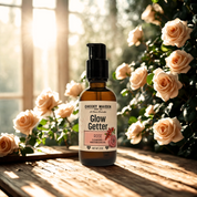 Bottle of 'Glow Getter' with roses in the background