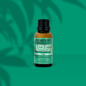 Tea Tree essential oil bottle with a green background